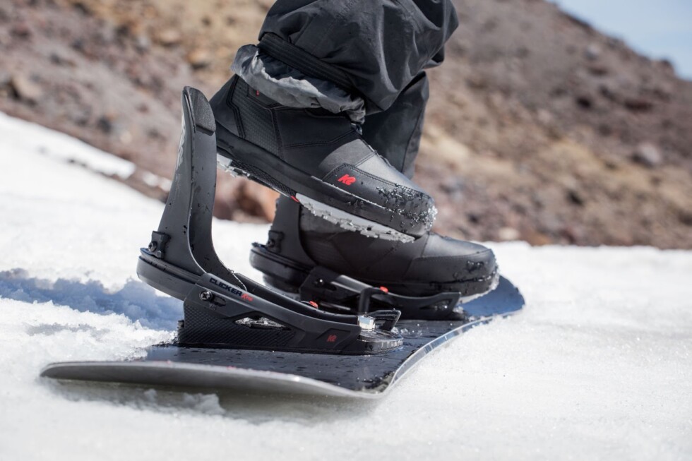 Mężczyzna zapina buty snowboardowe w nowoczesnym wiązaniu na śniegu