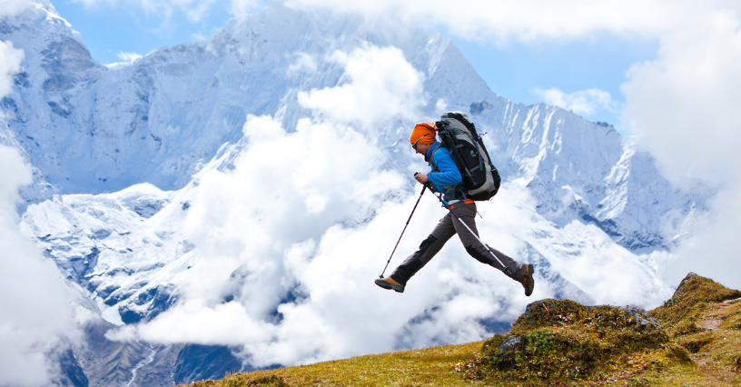 Osoba wędruje w górach z kijkami trekkingowymi