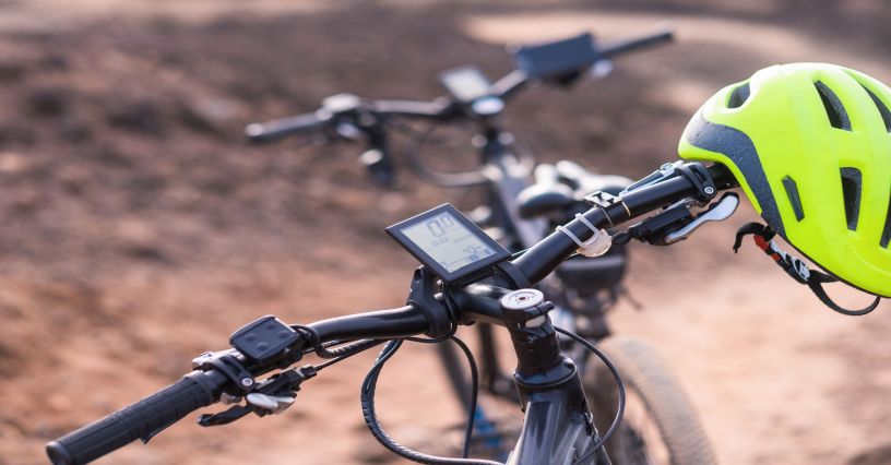 Licznik rowerowy na kierownicy z zawieszonym kaskiem