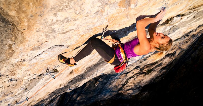 Kobieta wspinająca się po skale w butach wspinaczkowych La Sportiva