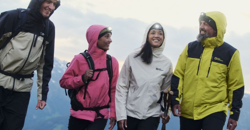 Grupa ludzi w kurtkach Jack Wolfskin 3 w 1 wędruje w górach