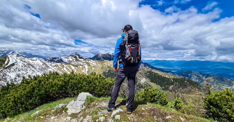 Mężczyzna z plecakiem trekkingowym podczas górskiej wycieczki wiosną